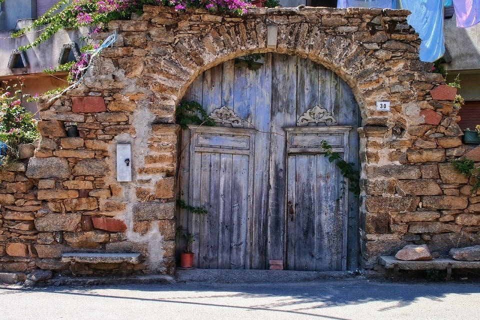 Il portone ad arco antico di una casa in pietra della Sardegna